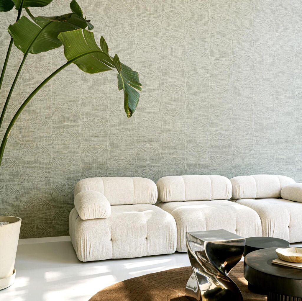 Moderne woonkamer met een lichtkleurige, comfortabele bank, Arte Pampas Cupula-behang en stijlvolle designaccessoires.