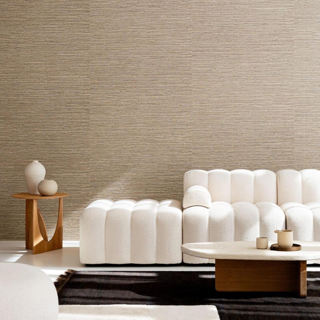 Moderne woonkamer met Arte Pampas Matiz 73523 behang, een licht gebogen witte bank, houten bijzettafel en ovale salontafel.