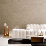 Moderne woonkamer met Arte Pampas Matiz 73523 behang, een licht gebogen witte bank, houten bijzettafel en ovale salontafel.