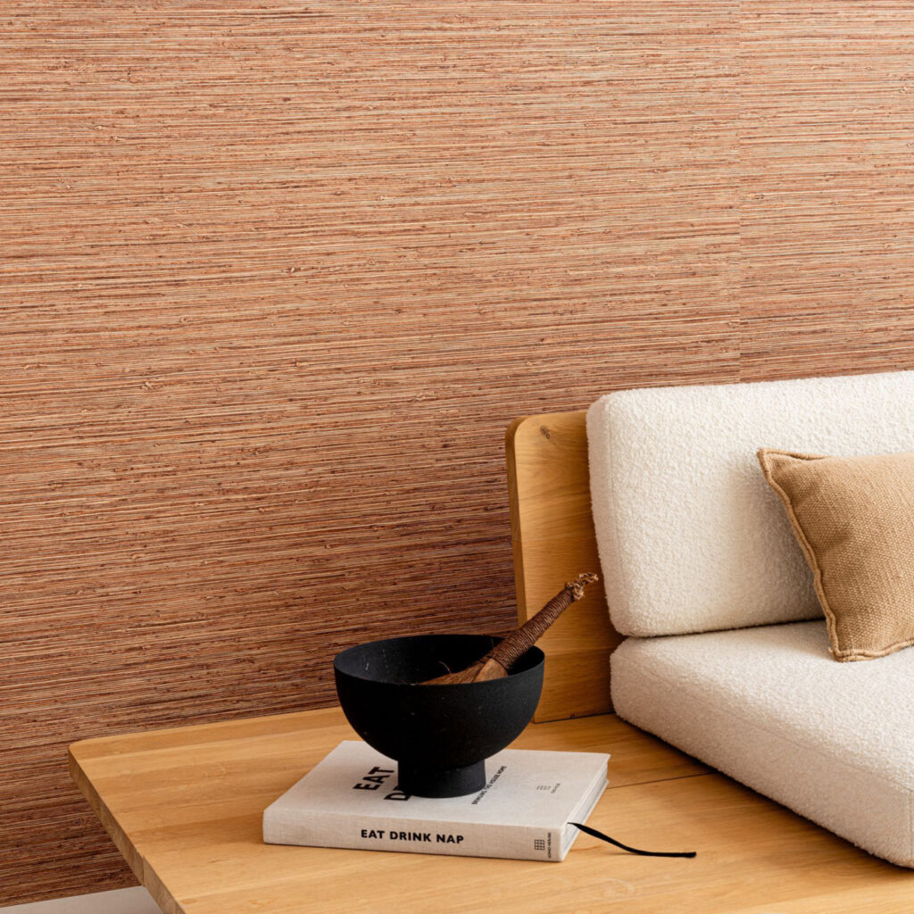 Moderne woonkamer met Arte Pampas Matiz 73526 behang, een lichte stoffen bank en houten bijzettafel met decoratieve accessoires.