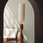 Moderne woonkamer met Arte Pampas Matiz 73532 behang, een houten vloerlamp en een retro bankje met witte bekleding.