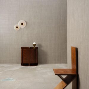 Minimalistisch interieur met Arte Pyxis 38008A wandbekleding, een houten kastje met lamp en een moderne houten stoel.