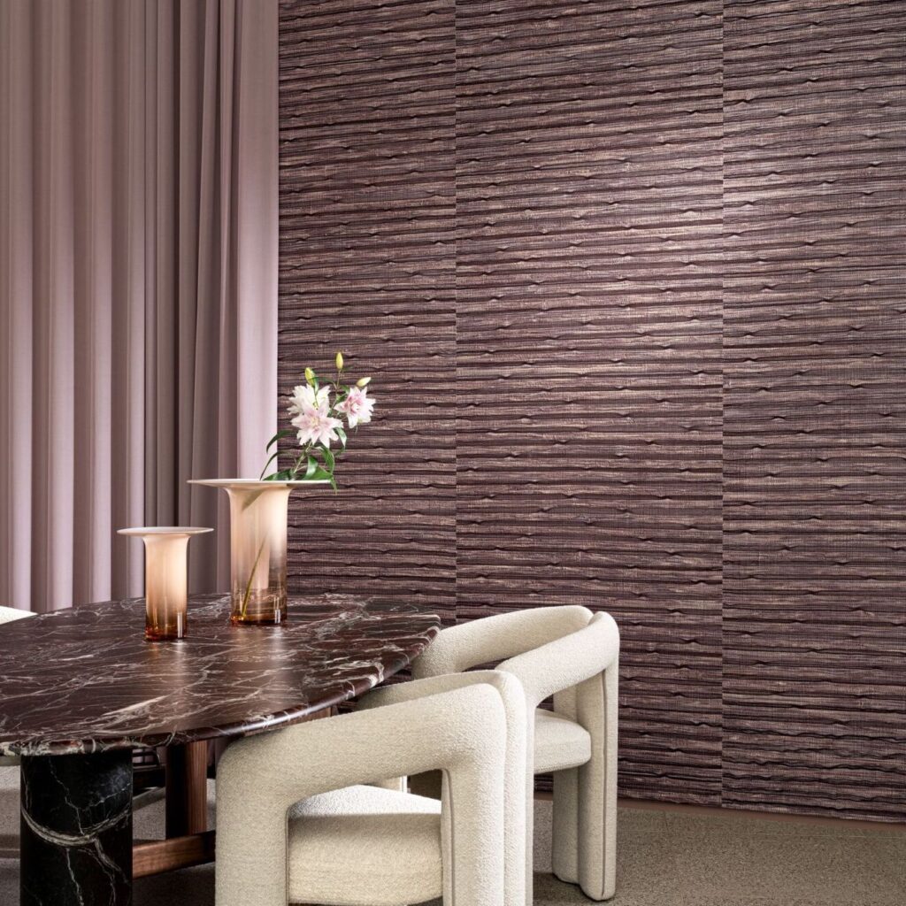 Eetkamer met Arte Raphia behang, een ovale marmeren tafel, zandkleurige stoelen en roze accenten.