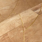 Close-up van Arte Rubra 40711 behang in de kleur Golden Natural met een natuurlijke houtstructuur en elegante gouden lijnen.