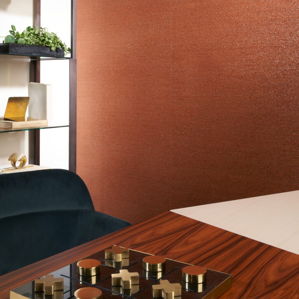 Moderne woonkamer met Arte Shimmer behang 40352 in koperkleur en luxe houten tafel met spel.