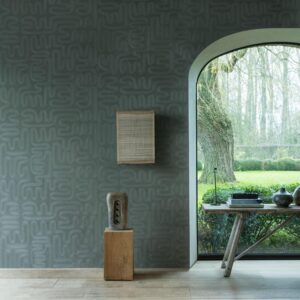 Sfeervolle interieurhoek met Arte Tali Sarana 60704 behang, houten accenten en uitzicht op een groene tuin.