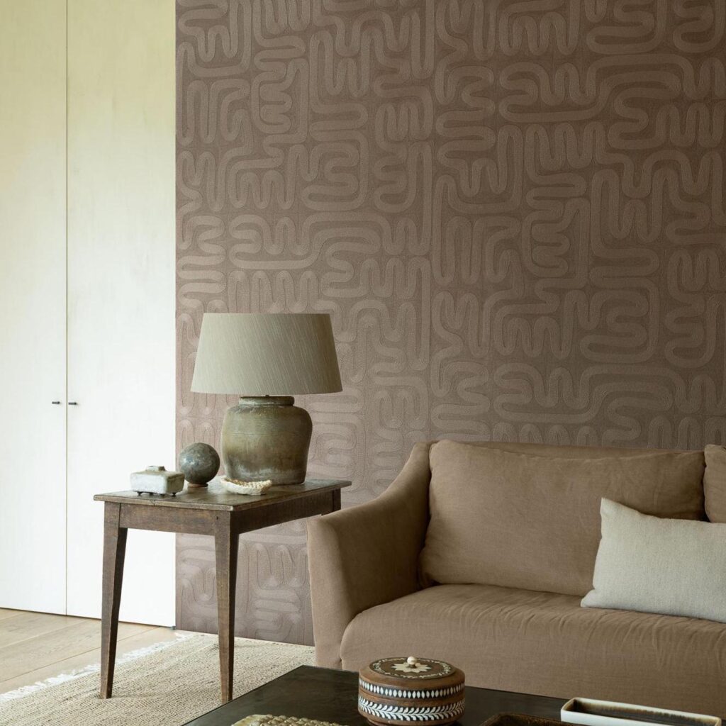 Sfeervolle woonkamer met Arte Tali Sarana 60710 behang in een organisch patroon en natuurlijke tinten.