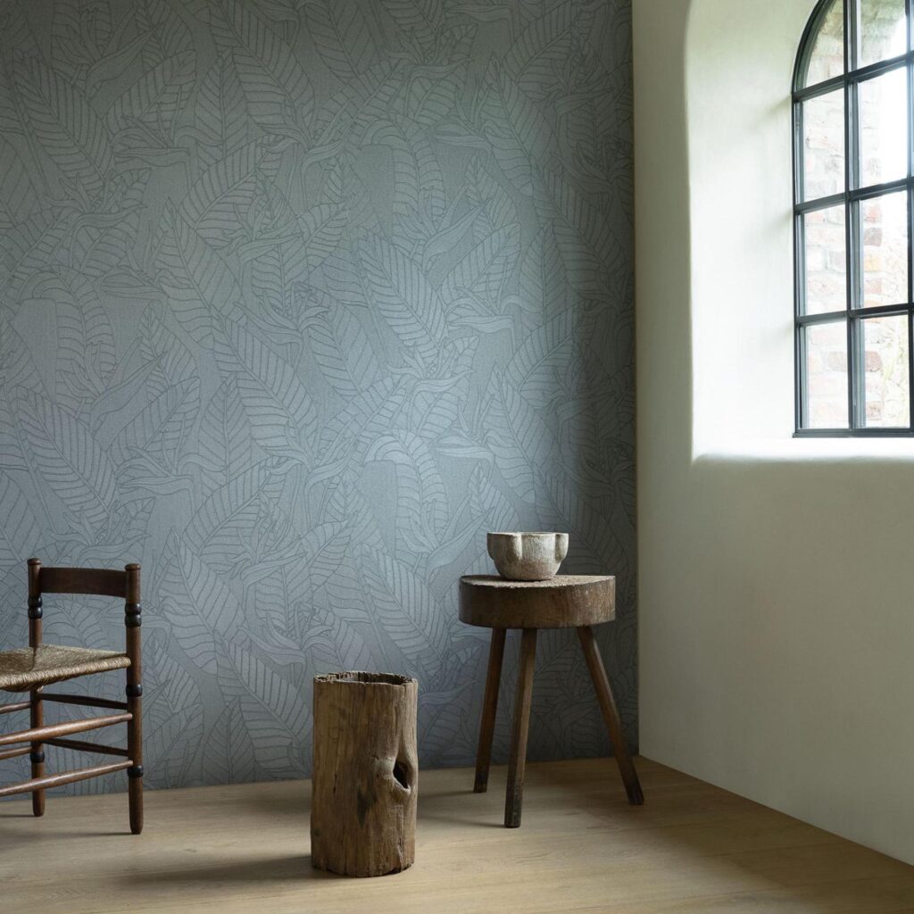 Minimalistisch interieur met Arte Tali Strelitzia behang in grijstinten en rustieke houten meubels.