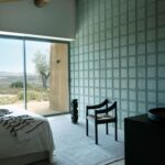 Modern ingerichte slaapkamer met Arte-Terra Arcilla 23934 wandbekleding en uitzicht op een mediterraan landschap.