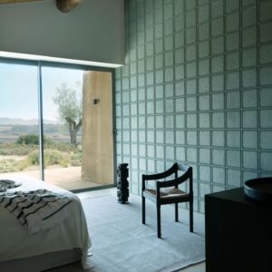 Modern ingerichte slaapkamer met Arte-Terra Arcilla 23934 wandbekleding en uitzicht op een mediterraan landschap.