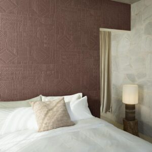 Slaapkamer met het Arte-Terra Carvato 23923-behang in aardetint met geometrisch reliëfpatroon achter een opgemaakt bed.