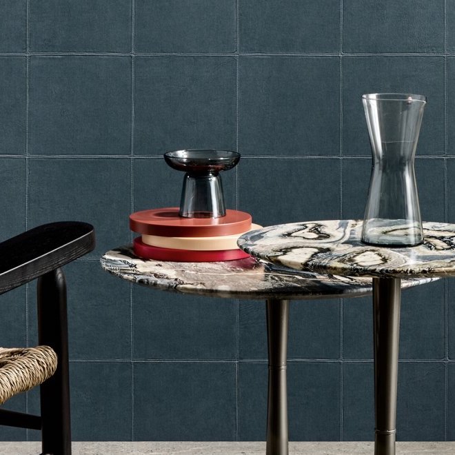 Moderne interieursetting met marmeren bijzettafels, glazen accessoires en een blauw getegelde Arte-Textura Campo 21040A muur.