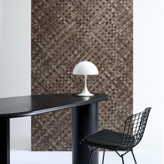 Moderne interieursetting met Arte-Textura Pandan behang, een zwarte designstoel, ovale zwarte tafel en een witte tafellamp.