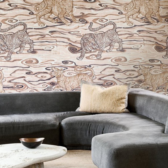 Moderne woonkamer met een grijze hoekbank en Arte Tigris-behang met gestileerde tijgers uit de Gitane-collectie.