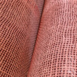 Detailopname van het roze geweven structuurpatroon van Arte Uno behang.