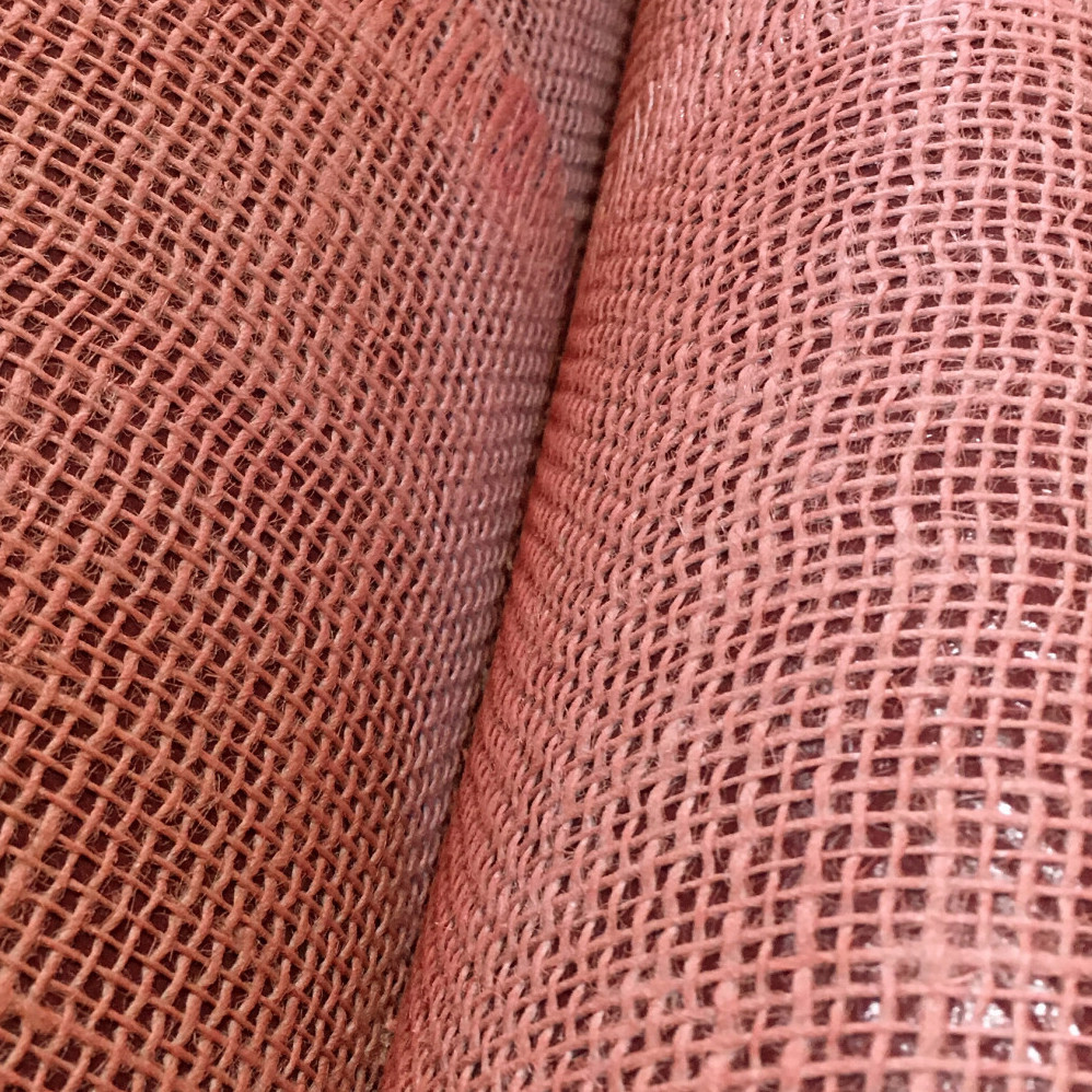 Detailopname van het roze geweven structuurpatroon van Arte Uno behang.