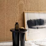 Zwart bijzettafeltje met decoratieve objecten voor Arte Uno behang in een natuurlijke linnenlook.