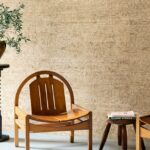 Houten stoel in een woonkamer met beige bloemmotief behang uit de Arte Ajoura Les Forêts collectie.