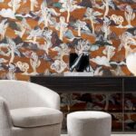 Moderne zithoek met Arte-behang Alaya Saranda 11541 met gestileerd boom- en wolkenmotief op een warme oranje achtergrond.