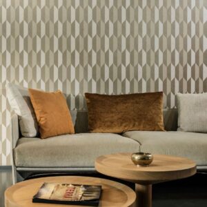 Zithoek met beige bank, bruine kussens en Arte-behang Arrow met geometrisch patroon op de achtergrond.