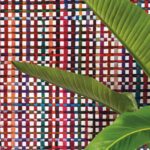 Twee grote groene bladeren voor kleurrijk geweven Arte-behang uit de Atelier Extravaganza collectie.