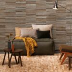 Sfeervolle woonkamer met Arte-behang Atelier Naturally Beautiful AT-21, een bank met kussens en plaid, en warme aardetinten in het interieur.