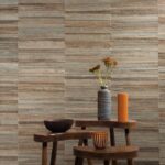 Sfeervolle interieursetting met Arte behang uit de Atelier Naturally Beautiful collectie, gecombineerd met houten tafeltjes en aardewerken accessoires.