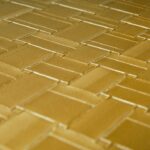 Close-up van het Arte behang Avalon Weave in een goudkleurig, geweven patroon.