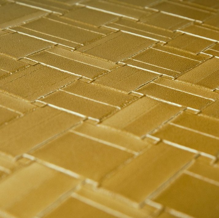 Close-up van het Arte behang Avalon Weave in een goudkleurig, geweven patroon.