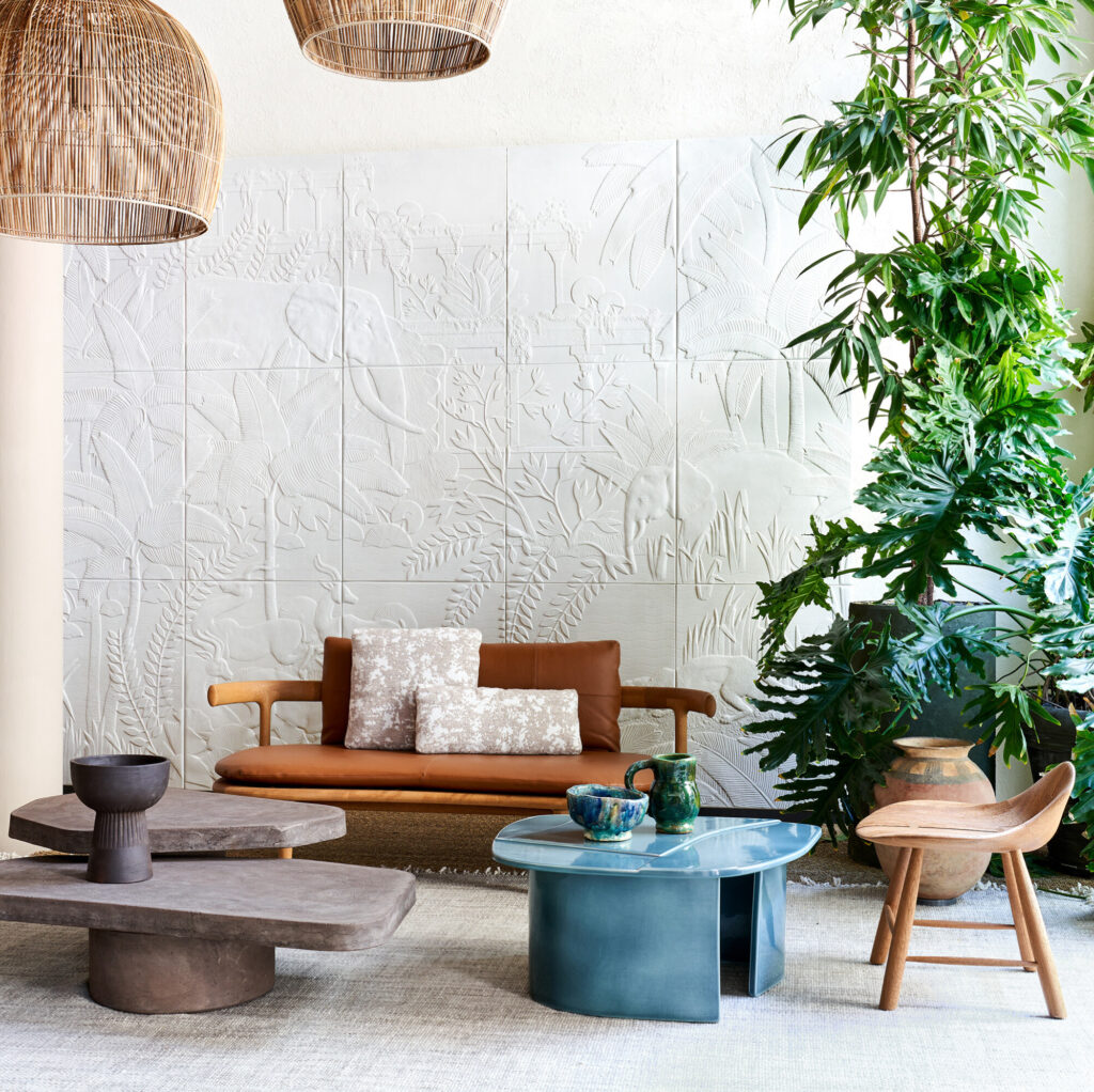 Sfeervolle interieursetting met Arte-behang Babylon Between Rivers 97000, een leren bank, design tafels en veel groen.