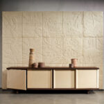 Luxe interieur met Arte-behang Babylon Between Rivers 97003 met reliëf van jungle en olifanten, achter een modern dressoir met aardetinten.