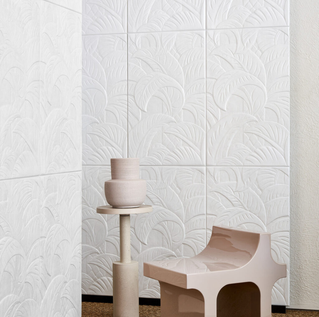 Moderne ruimte met Arte-behang Babylon Medjoul in reliëf met bladmotief, aangevuld met een designstoel en keramische vazen.