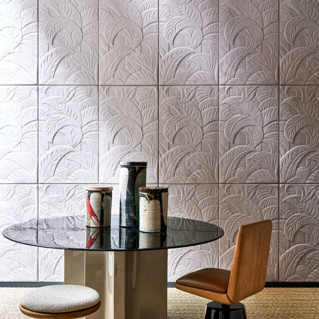 Moderne eetkamer met Babylon Medjoul behang van Arte met een palmbladreliëf, ronde tafel en decoratieve vazen.