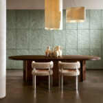Moderne eetkamer met Arte-behang Babylon Medjoul, een ovale houten tafel, neutrale designstoelen en aardewerken vazen.