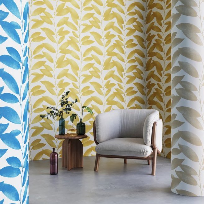 Moderne zithoek met Arte-behang Blooming Marvellous met geel bladpatroon en een beige fauteuil.