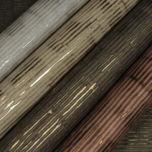 Vier rollen Arte Cobra CA5 behang met glanzende, houtnerfachtige textuur in grijs-, beige-, bruin- en koperkleuren.