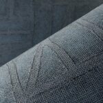 Close-up van het Arte behang Essentials Costura Bojagi 57543 met een blauwgrijs reliëf en textielstructuur.