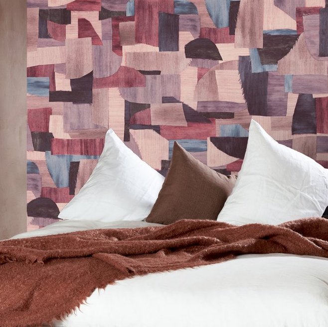 Sfeervolle slaapkamer met het abstracte Arte Essentials Costura Urban 57603 behang in paars-roze tinten.