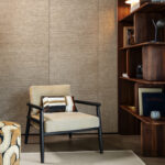 Zithoek met beige fauteuil en Arte-behang Essentials Les Naturels Le Raphia Tissé 26744 op de achtergrond.
