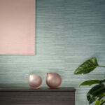 Interieur met groen Arte-behang Essentials Les Naturels Le Sisal 26700, roze decoratieve vazen en een groene kamerplant.