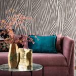 Moderne woonkamer met Arte-behang Essentials Travellers Damara, een roze bank en kleurrijke accessoires.