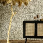 Interieur met Arte-behang Essentials Travellers Pelage, een rotan kastje en decoratieve elementen.