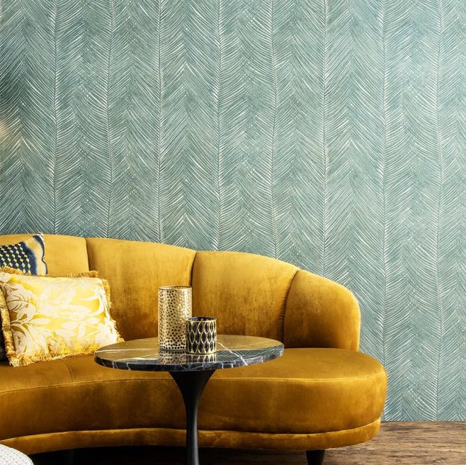 Gele fluwelen bank met sierkussens voor een muur met groen Arte Essentials Travellers Talamanca behang.