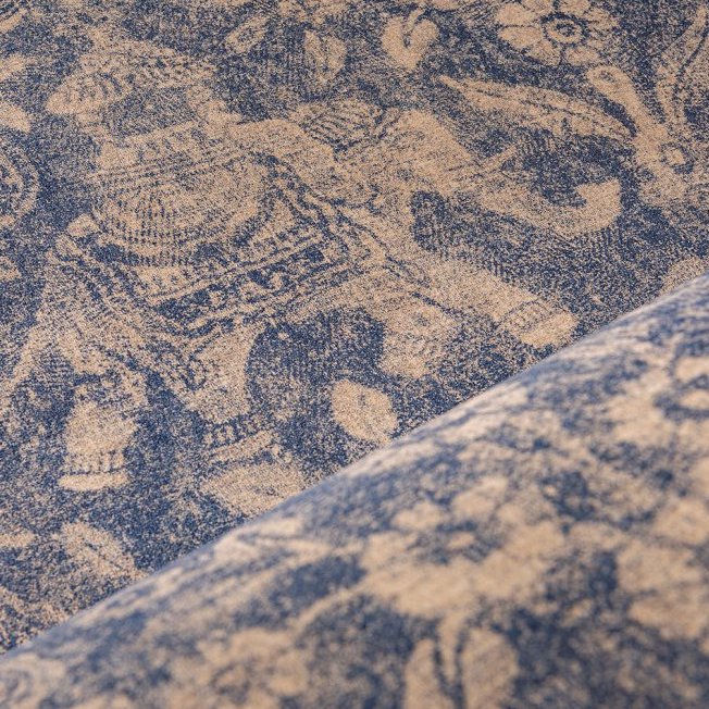 Close-up van Arte behang uit de Essentials Travellers Tantor collectie met een gedetailleerd motief van een gedecoreerde olifant in blauw en beige.