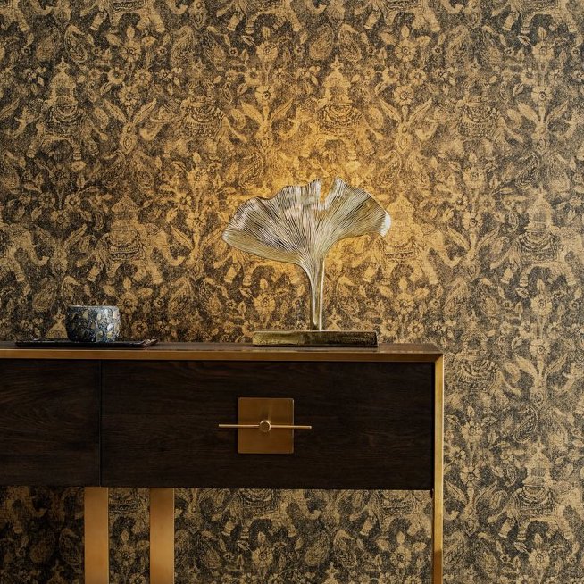 Donker houten dressoir met goudkleurige accenten tegen een luxueus Arte Essentials Travellers Tantor3 behang met exotisch patroon.