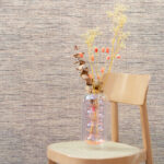 Vaas met gedroogde bloemen op een houten stoel voor Arte-behang uit de Essentials Palette collectie, model Le Papier Tissé 60500B.