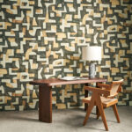 Moderne interieursetting met Arte Essentials Totem Ecoline 18902 behang, een houten bureau, designstoel en tafellamp.
