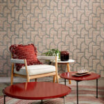 Interieur met Arte-behang Essentials Totem Esparto Iberico, een houten stoel met rood kussen, rode salontafels en een plant op een bijzettafel.