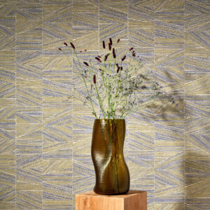 Bruine vaas met bloemen op houten sokkel voor geometrisch Arte-behang uit de Essentials Totem Infinity 18932 collectie.