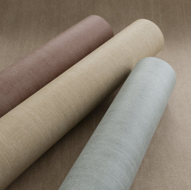 Drie rollen Arte Essentials Washed Linen behang in verschillende natuurlijke kleuren op een bijpassende ondergrond.